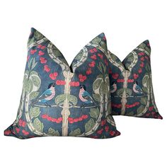 two blue pillows with red berries and birds on them, one is made out of fabric