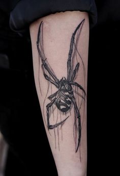 a black and white spider tattoo on the arm