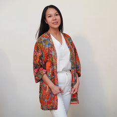 This is a washable printed batik robe/ kimono handmade by artisans, thick duster and home jacket. Because of the upcycled material and handmade nature of this item, each batik quilt kimono is not alike. The print will be of slightly different pattern and color but in variation of black, blue, pink, purple, green mix pattern. This thick quilted patchwork robe is handmade by artisans in Java using upcycled printed fabric from leftover fabric sourced from clothing manufacturer. Outer layer: 100% co Oversized Bohemian Outerwear With Floral Print, Oversized Bohemian Floral Print Outerwear, Multicolor Printed Outerwear With Kimono Sleeves, Bohemian Patterned Kimono With Vibrant Print, Oversized Printed Outerwear With Kimono Sleeves, Spring Cotton Kimono With Batik Print, Cotton Batik Print Kimono For Spring, Multicolor Kimono With Kimono Sleeves, Bohemian Outerwear With Floral Print And Kimono Sleeves