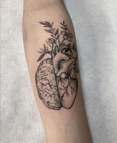 a black and white tattoo of a human heart with a plant growing out of it