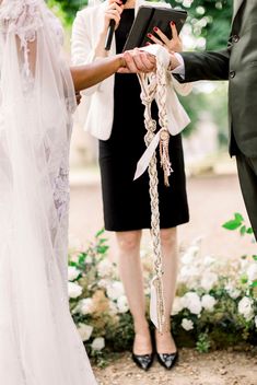 a bride and groom holding hands during their wedding ceremony