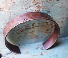 "Our rustic cuff is hand forged from rich copper, this cuff is a unique statement piece. Cuffs are hammered and hand stamped with the Roman Numeral date of your choice. An anniversary, child's birthday or any special date you would like to commemorate. The cuff is oxidized in an organic solution to give it a rich, warm patina and bring out the details. *SIZING* The circumference of each cuff is the size in inches plus a 1.25\" to 1.5\" gap. To get the size measure the wrist and compare it to the Mens Copper Bracelet, Roman Numeral Bracelet, 22nd Anniversary, Roman Numerals Dates, 7th Anniversary Gifts, 7th Anniversary, Rustic Cuff, Copper Cuff, Copper Bracelet