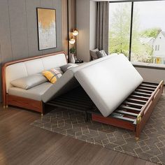 a bed with two mattresses on top of it in a room next to a window