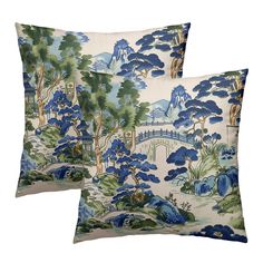 two blue and white pillows with trees, bushes and bridge in the background on a white background