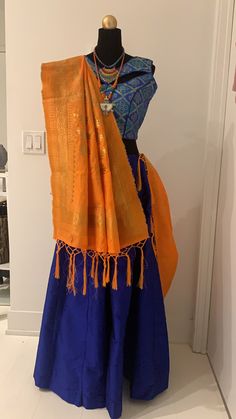 Blue chanya choli with orange dupatta. Blue chanya(skirt) has made up of Tafeta silk. Brocade Blouse with unique pattern of blue and golden threads comes with extra sleeves. Orange dupatta with golden zari threads. Item Contain : Blue and orange chanya choli set Chanya(skirt) Length : 42 Inches Blouse Length : 14.5 Inches Sleeves : Sleeveless (But it has extra sleeves of length 5 Inches) Item In Box: 3 pc outfit Color : Blue ( As Shown In Image ) Fit Type : Regular Fit Occasion: Will add luster when worn for a wedding, engagement, party, prom, navratri(garba) and any special occasion. It will enhance special days like Valentine's Day, Birthdays, Anniversaries and Mother's Day Gift. Color Declaration: There Might Be Slight Variation In The Actual Color Of The Product Due To Different Screen Blue Dola Silk Pre-draped Saree With Pallu, Blue Silk Sharara With Traditional Drape, Bollywood Style Pre-draped Saree With Tilla For Navratri, Blue Traditional Drape Sharara For Navratri, Orange Silk Anarkali Set For Navratri, Royal Blue Sharara For Navratri Festival, Festive Royal Blue Sharara For Diwali, Orange Raw Silk Sharara With Pallu, Blue Anarkali Set With Pallu For Navratri