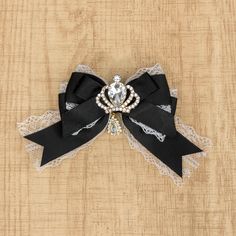 a black and white bow with a crystal brooch on it's headband