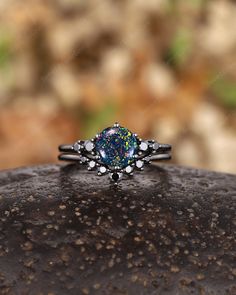 a ring with an oval shaped blue opal surrounded by small white and yellow stars