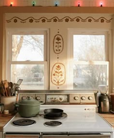 a stove top oven sitting inside of a kitchen next to a window with lights on it