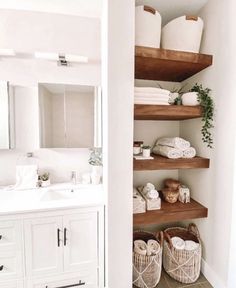 a white bathroom with open shelving and baskets