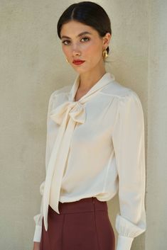 This blouse is exquisitely crafted from upcycled Charmeuse silk. The French bow blouse design effortlessly elevates the classic button-up style, infusing it with femininity and charm. Experience the luxury of its lustrous and comfortable feel against your skin, ensuring a delightful wearing experience. The model measures 175 cm and is wearing a size XS. Silk Blouse Outfit, Feminine Blouses, Slow Fashion Brands, Bow Blouse, Made Clothing, Blouse Outfit, White Blouse, Slow Fashion, Silk Blouse