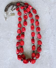 This eye-catching Necklace showcases 2 Strands of Bamboo Coral Oval Nuggets. The Nuggets are a lively coral-red with characteristic black markings, and have been cut with 2 flat sides and a flat round circumference. The structure is both uncommon and attractive. The Coral is slightly graduated — ranging from 11-by-14mm to 14-by-18mm. The stones have been polished to a glossy sheen. We've paired the Coral Nuggets with 17 6mm Oxidized Sterling Silver Rounds, adding subtle shine. The Sterling is co Bamboo Coral, Southwest Design, The Coral, Color Depth, Coral Red, Toggle Clasp, Quartz Stone, Strand Necklace, Shades Of Red