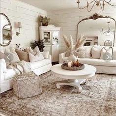 a living room filled with white furniture and lots of pillows on top of a rug