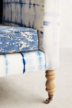 a blue and white chair with an upholstered arm rest on it's legs