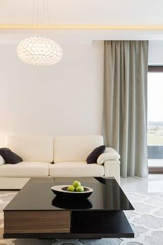 a living room filled with furniture and a chandelier hanging over the top of it