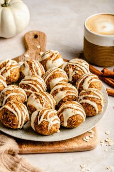 a plate full of cinnamon roll cookies with icing on top and cinnamon sticks next to it