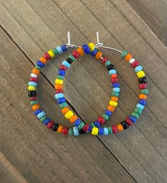 These medium sized hoop earrings are very vibrant and fun.  They are light on the ears and just the right size.  The silver- plated hoops are about 1 1/4 inches in diameter and are made of multicolored glass seed beads.    If there is a color that you do not see I should be able to make a custom pair for you.  Please, message me with your color preference.  *If you would like to buy 2 pair and receive one free,  go to this listing: https://www.etsy.com/listing/1106456212/medium-sized-hoop-earrings-custom-beaded?click_key=4547325c485bf0417bb8b88a0bcb51080bc1e9d5%3A1106456212&click_sum=2b5e1743&ref=shop_home_active_5&pro=1&frs=1 In order to choose your desired color, simply pick the picture that has your color.  Then, choose the number.   All earrings are packaged in a pretty white drawstrin Olive Earrings, Antique Silver Earrings, Boho Hoop Earrings, Handmade Hoop Earrings, Medium Hoop Earrings, Dangle Hoop Earrings, Earrings Colorful, Earring Gift, Earring Tree