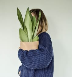 a woman holding a potted plant behind her back