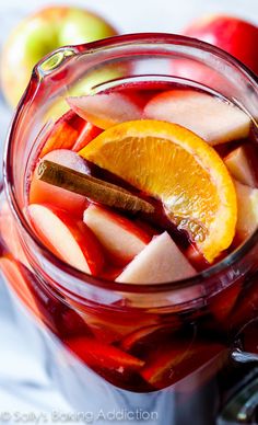 a pitcher filled with apple cider and sliced apples