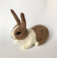 a brown and white stuffed rabbit on a white background