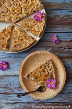 there is a pie with bananas on it and purple flowers next to the pie plate