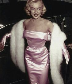 a woman in a pink dress and fur coat