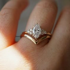 a woman's hand with a gold and white diamond ring on top of her finger