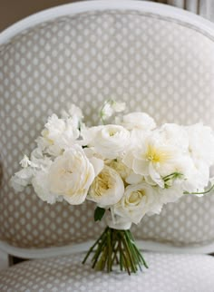 a bouquet of white flowers sitting on top of a chair