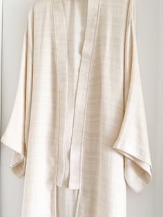 Elevate your lounge wear style with the Ivory Smooth Textured Turkish Cotton Kimono, woven with a beautifully intricate pattern that feels incredibly soft against the skin. Crafted from 100% Turkish Cotton, it ensures both comfort and style for your moments of relaxation at home. Available in one size. Color: Ivory. Material: 100% Cotton. Made in Turkey. Unisex one size. Machine wash delicate. Tumble Dry low. Cream Kimono For Spring Loungewear, Spring Cream Kimono For Loungewear, White Spring Kimono For Relaxation, Beige Relaxed Fit Kimono For Loungewear, Relaxed Fit Beige Kimono For Loungewear, Cream Long Sleeve Kimono For Loungewear, Elegant Long Sleeve Relaxed Fit Kimono, Beige Long Sleeve Kimono For Loungewear, Beige Cotton Kimono With Relaxed Fit