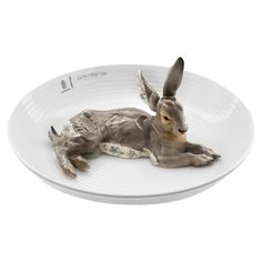 a ceramic animal laying on top of a white plate