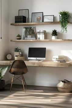 a desk with a computer, books and plants on the top shelf in front of it