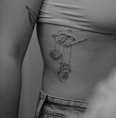 a woman's stomach with two hearts hanging from strings on the left side of her belly