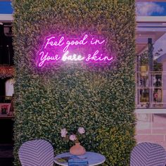 a purple neon sign that reads, feel good in your bare skin