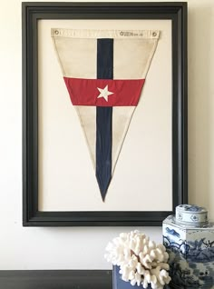 an old flag hanging on the wall next to a vase