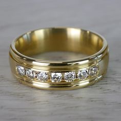 a yellow gold wedding band with five diamonds