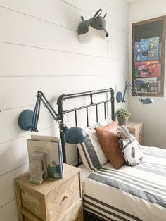 a bed room with a neatly made bed and two lamps on the wall above it