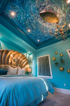 a bedroom decorated in blue and gold with a ceiling painted like an ocean wave,