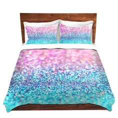 a bed with blue, pink and purple glitters on the comforter cover is shown