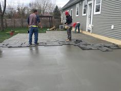 two men are working on the roof of a house