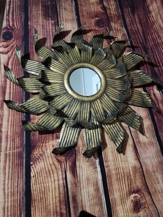 a mirror that is on the side of a wooden wall with a sun design in it