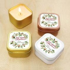 three tins filled with candles sitting on top of a table