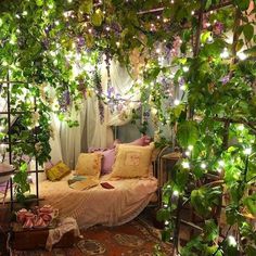 a bedroom with lots of greenery on the walls and bed in the center, surrounded by lights