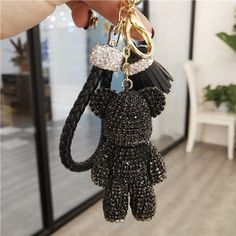 a person holding up a black and white keychain