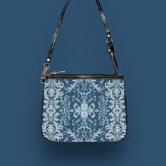 This unique and vibrant shoulder bag adds a chic touch to any outfit. Its compact size (10"w x 8"h) and lightweight construction makes it the perfect accessory for carrying around your essentials in style. Our one of a kind purse features an archival fabric design in baroque flourishes of sapphire, sky and pale blues. This gorgeous design is printed onto high-grade vegan leather and shipped to you by our top-rated production partner. We also offer the coordinating vegan wallet: https://thecheeky Crossbody Evening Bag With Removable Pouch, Modern Shoulder Bag As Fashion Accessory, Blue Satchel Baguette Bag With Detachable Strap, Blue Baguette Satchel Bag With Detachable Strap, Trendy Handheld Bag With Zipper Pouch, Trendy Satchel Shoulder Bag With Zipper Pouch, Luxury Everyday Shoulder Bag With Zipper Pouch, Everyday Clutch Shoulder Bag With Detachable Handle, Everyday Use Clutch Shoulder Bag With Detachable Handle