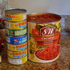 several cans of canned food sit on a kitchen counter