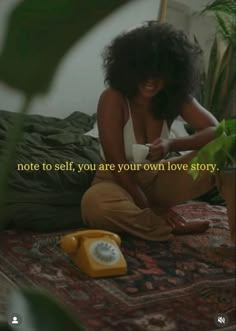 a woman sitting on top of a bed next to a plant and an old phone