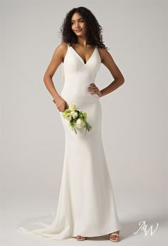 a woman in a white wedding dress posing for the camera with her hands on her hips