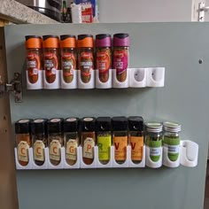 spices are lined up on the wall next to each other in different colors and sizes