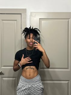 a woman with dreadlocks standing in front of a door taking a selfie