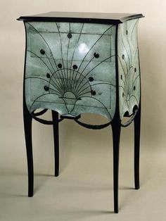 an ornate glass cabinet with black legs and drawers is shown against a white background that has the word scala on it