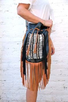 Boho style fringed leather bag black with tan fringes and white bone choker Bone bead choker attached as decoration Fully lined inside with one pocket. strap can be adjusted to several lengths. Material: leather, cow bones 26 cm wide,39 cm long. total long include leather fringes 60 cm Best finishing quality Please note that our products are handmade with some natural materials. For this reason the used materials such as leather and feathers may have slight variations in color. Please do not for Black Tasseled Hobo Bag, Chic Brown Hobo Bag With Tassels, Chic Brown Fringe Hobo Bag, Black Bohemian Bag With Fringe, Bohemian Leather Shoulder Bag With Fringe, Black Bohemian Shoulder Bag With Tassels, Brown Shoulder Bag With Tassels For Festival, Festival Brown Hobo Bag With Fringe, Brown Fringe Hobo Bag For Festival